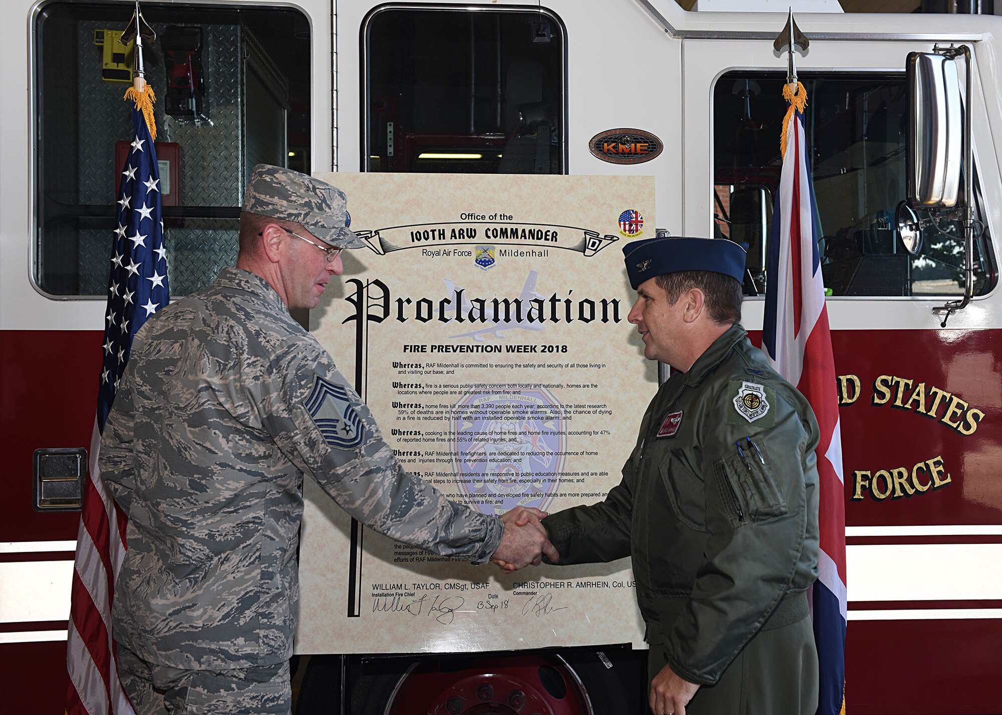 U.S. Air Force Col. Christopher Amrhein, 100th Air Refueling Wing commander, shakes hands with U.S. Air Force Chief Master Sgt. William Taylor, 100th Civil Engineering Squadron installation fire chief, after the signing of the 2018 Fire Prevention Week Proclamation at RAF Mildenhall, England, Sept. 13, 2018.  Fire Prevention Week is Oct. 7 – 13, and this year's theme is "Look, Listen, Learn." The fire department has a variety of events schedule for throughout the week for Team Mildenhall members and their families. (U.S. Air Force photo by Senior Airman Luke Milano)