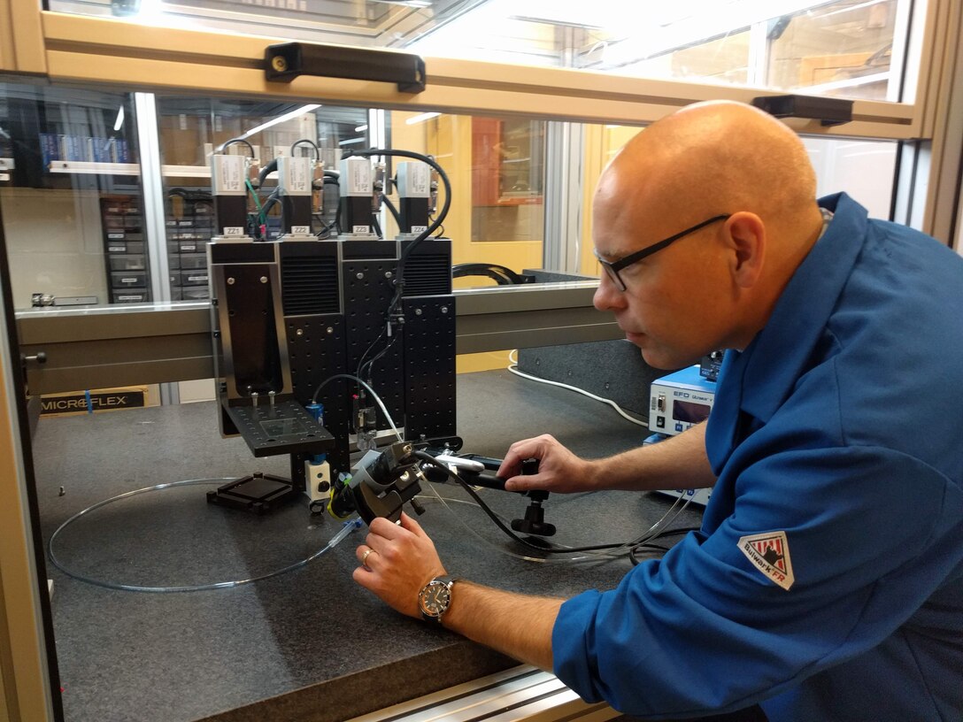 Dr. Matthew Dickerson, Laboratory University Collaboration Initiative fellow award recipient, assembles an additive manufacturing system.