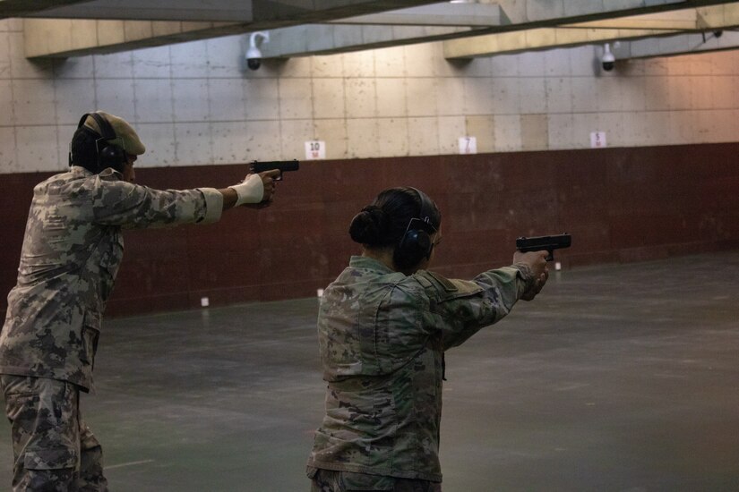 Spc. Alizon Gonzalez, Alpha Company, 578th Brigade Engineer Battalion, fires a handgun alongside an officer from the Qatar Central General Depot at the Qatar Special Forces range compound, Sep. 9, 2018. The range event provided a unique opportunity for Soldiers to build rapport with the Qatari soldiers from a Qatari base near Camp As Sayliyah.