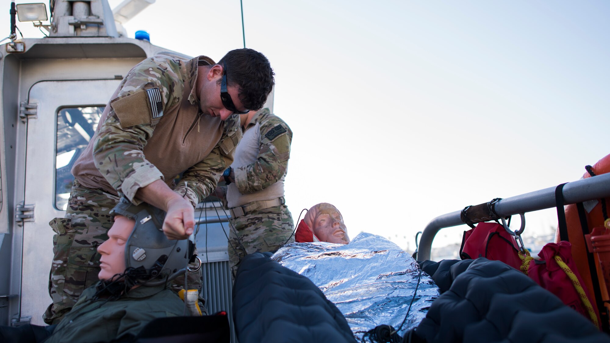 Staff Sgt. Alan Hamilton, 27th Special Operations Support Squadron Survival, Evasion, Resistance and Escape specialist, straps a flight helmet onto a training dummy during a full mission profile exercise at Channel Islands Harbor in Oxnard, Calif., Sept. 18, 2018. Airmen boarded a U.S. Coast Guard boat and tested search and rescue operations with cooperating aircraft. An FMP provides participants the opportunity to refine their tactics, techniques and procedures in operating in a maritime environment. (U.S. Air Force photo by Staff Sgt. Michael Washburn)