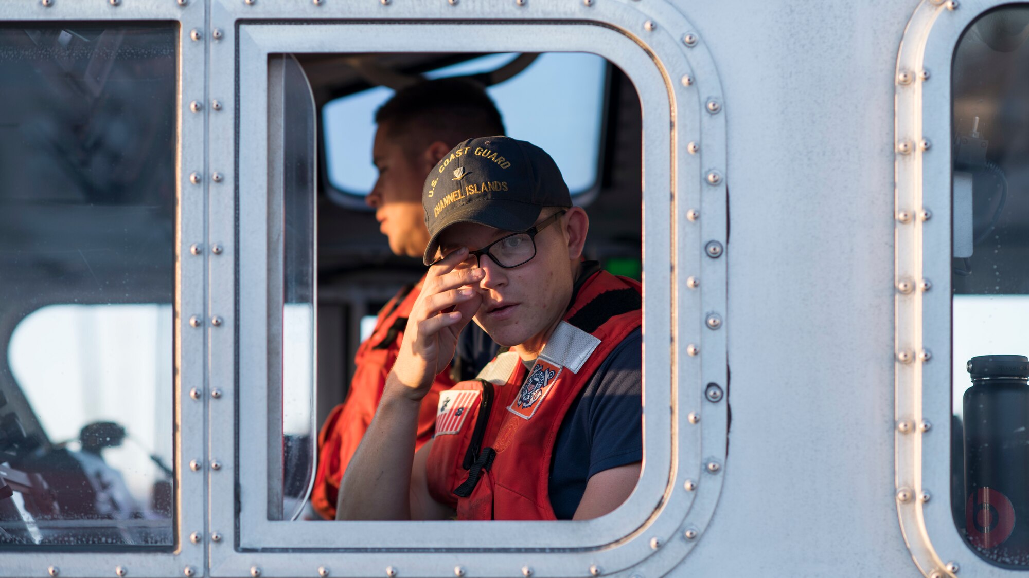 A U.S. Coast Guardsman looks out the side of a boat during a full mission profile exercise at Oxnard, Calif., Sept. 18, 2018. Airmen boarded a U.S. Coast Guard boat and tested search and rescue operations with cooperating aircraft. An FMP provides participants the opportunity to refine their tactics, techniques and procedures in operating in a maritime environment. (U.S. Air Force photo by Staff Sgt. Michael Washburn)