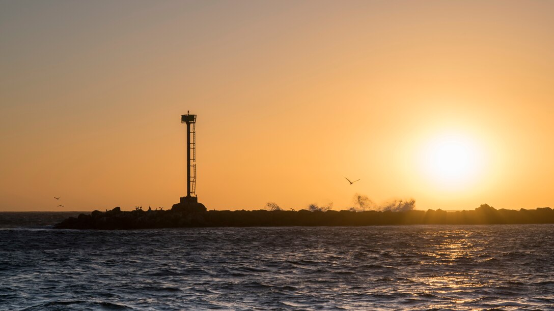 Waves crash against rocks as the sun sets at Channel Islands Harbor in Oxnard, Calif., Sept. 18, 2018. Airmen boarded a U.S. Coast Guard boat and tested search and rescue operations with cooperating aircraft. (U.S. Air Force photo by Staff Sgt. Michael Washburn)