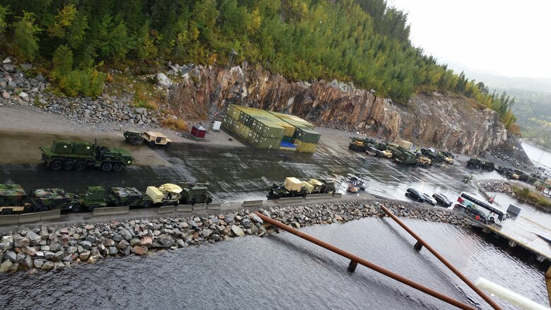U.S. Marines with II Marine Expeditionary Force, Norwegian service members and federal employees of Norway observe the stage vehicles after off-loading in preparation for NATO exercise Trident Juncture from ARC Resolve in Hammernesodden, Norway, Sept. 24, 2018. Marines and service members from the Norwegian Armed Services unloaded nearly 200 military vehicles and more than 70 containers with military equipment as planned in two days despite cold weather with periods of rain and sleet. Seven different organizations, which had never worked together before came together on a shortened timeline and conducted a successful operation, said Maj. Valerie Schwindt, operations officer, Arrival and Assembly Operation Group, II MEF. Trident Juncture is the largest live NATO exercise since 2002 and is scheduled to take place in October with more than 40,000 troops from 28 allied nations participating.