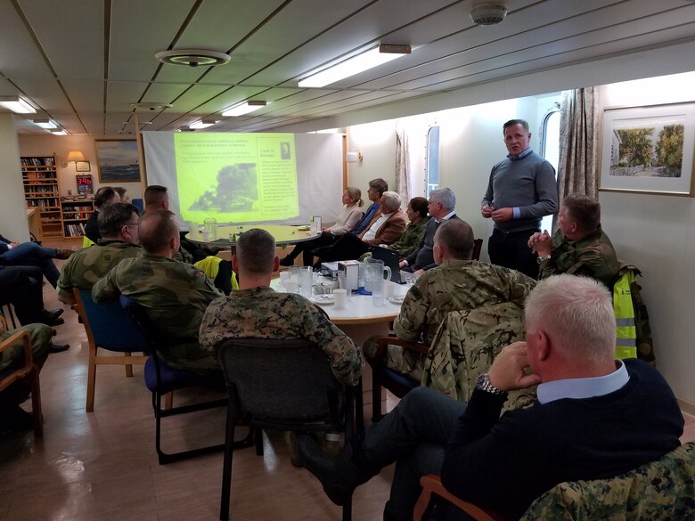 U.S. Marines with II Marine Expeditionary Force, Norwegian service members and federal employees of Norway attend a brief regarding the after off-loading of military vehicles and equipment in preparation for NATO exercise Trident Juncture from ARC Resolve in Hammernesodden, Norway, Sept. 24, 2018. Marines and service members from the Norwegian Armed Services unloaded nearly 200 military vehicles and more than 70 containers with military equipment as planned in two days despite cold weather with periods of rain and sleet. Seven different organizations, which had never worked together before came together on a shortened timeline and conducted a successful operation, said Maj. Valerie Schwindt, operations officer, Arrival and Assembly Operation Group, II MEF. Trident Juncture is the largest live NATO exercise since 2002 and is scheduled to take place in October with more than 40,000 troops from 28 allied nations participating.