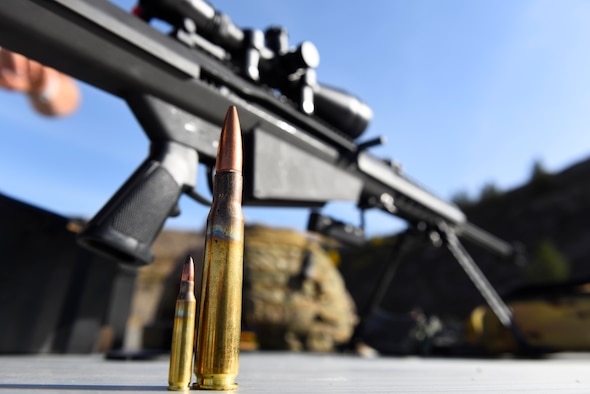 A .50-caliber bullet and a 7.62mm bullet rest in fron of a Barret M107 caliber rifle at Coulee Dam, Washington, Sept. 26, 2018. Airmen from the 92nd Civil Engineer Squadron explosive ordinance team underwent familiarization training with the Barret M107 caliber rifle as part of their annual weapons qualification. (U.S. Air Force photo/Airman 1st Class Lawrence Sena)