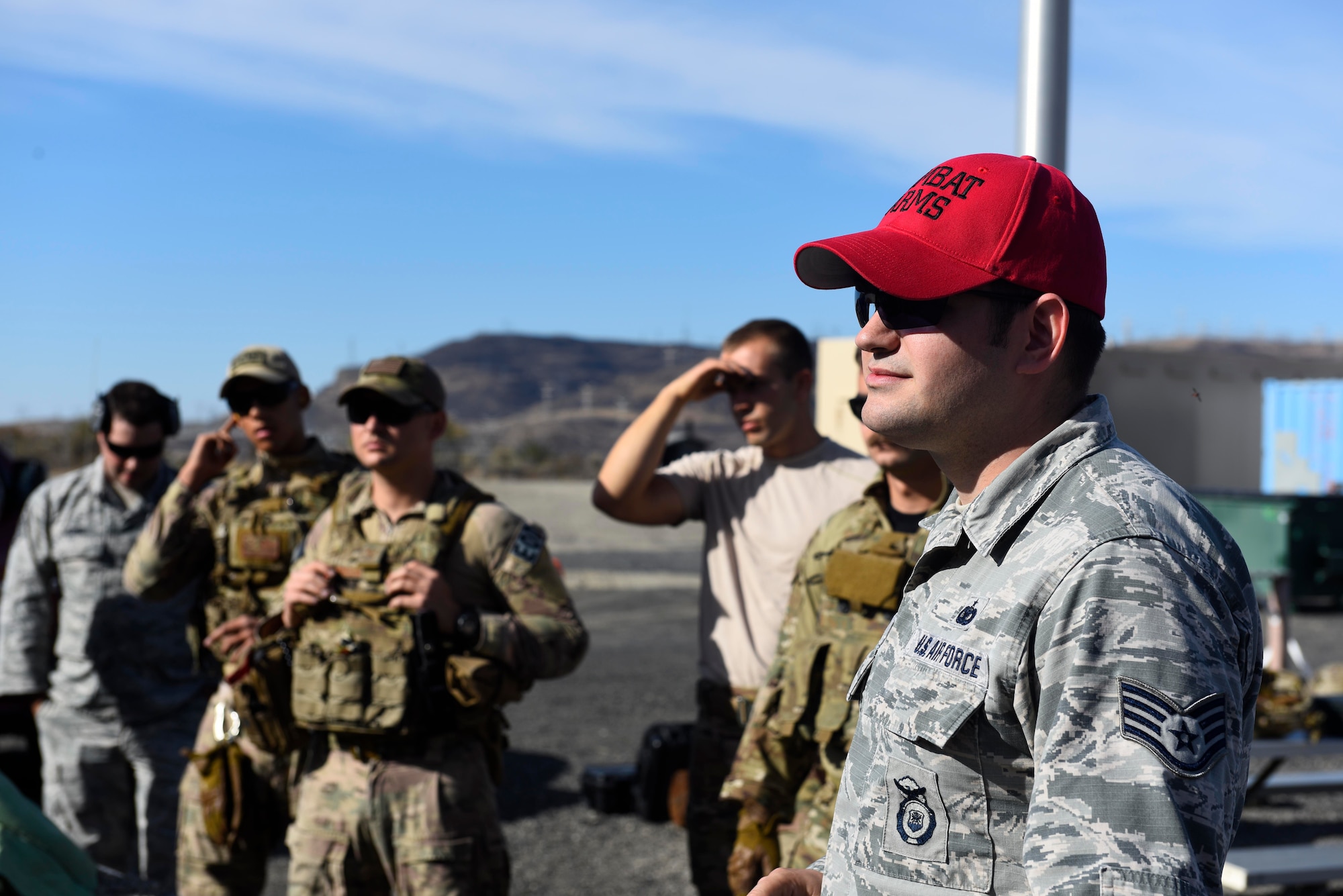 Staff Sgt. Jeffrey Janke, 92nd Security Forces Squadron combat arms instructor, listens to a safety brief prior to weapons qualifications  at Coulee Dam, Washington, Sept. 26, 2018.Airmen perform weapons qualifications annually in order to maintain versatility with the variety of weapons systems that may be utilized down range. (U.S. Air Force photo/Airman 1st Class Lawrence Sena)
