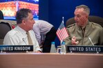Marine Corps Gen. Joe Dunford, chairman of the Joint Chiefs of Staff, speaks to British Army Gen. Sir Nicholas Carter, chief of the defense staff, prior to the start of a session during the NATO Military Committee Conference in Warsaw, Poland.