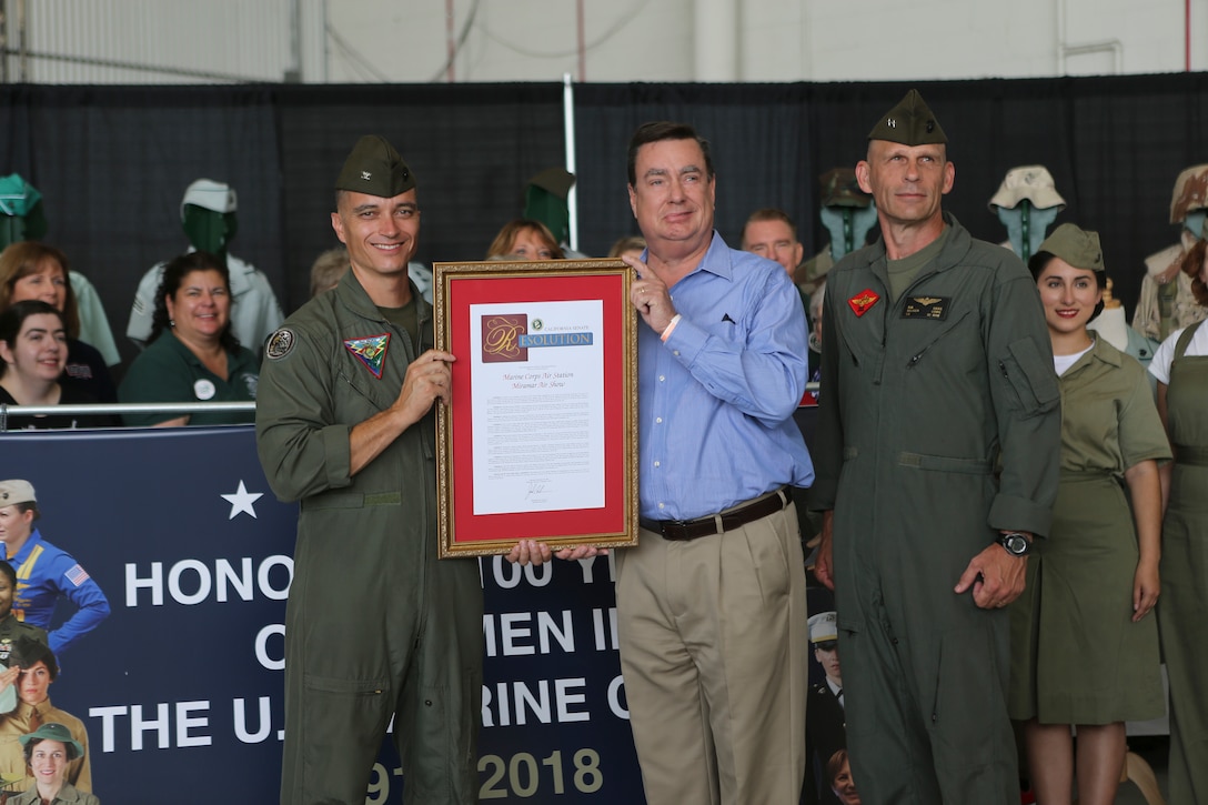 The Commanding Officer of Marine Corps Air Station Miramar, Col. Charles B. Dockery, far left, California State Senate member, Joel Anderson, center, and the Commanding General of 3rd Marine Aircraft Wing, Maj. General Kevin M. Liams, center right, pose for a photo with a proclamation dedicated to commending the efforts of MCAS Miramar for honoring 100 years of women in the U.S. Marine Corps at MCAS Miramar, Calif., Sept. 30. This year’s air show honors “100 years of women in the Marine Corps” by featuring several performances and displays that highlight the accomplishments and milestones women have made since the first female enlistee, Opha May Johnson, who joined the service in 1918. (U.S. Marine Corps photo by Cpl Nadia J. Stark)