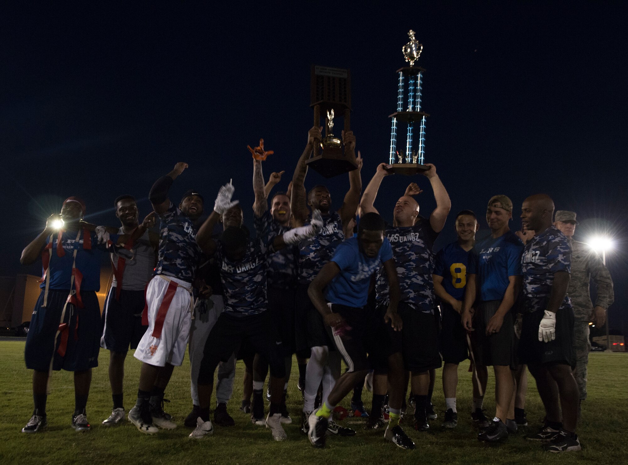The 97th Logistics Readiness Squadron football team celebrates winning the 97th Air Mobility Wing Flag Football Championships Sept. 28, 2018 on Altus Air Force Base, Okla. The 97th OSS and the LRS played two games against each other with the 97th Operations Support Squadron winning the first, and LRS winning the second to become the champions. (U.S. Air Force photo by A1C Jeremy Wentworth)