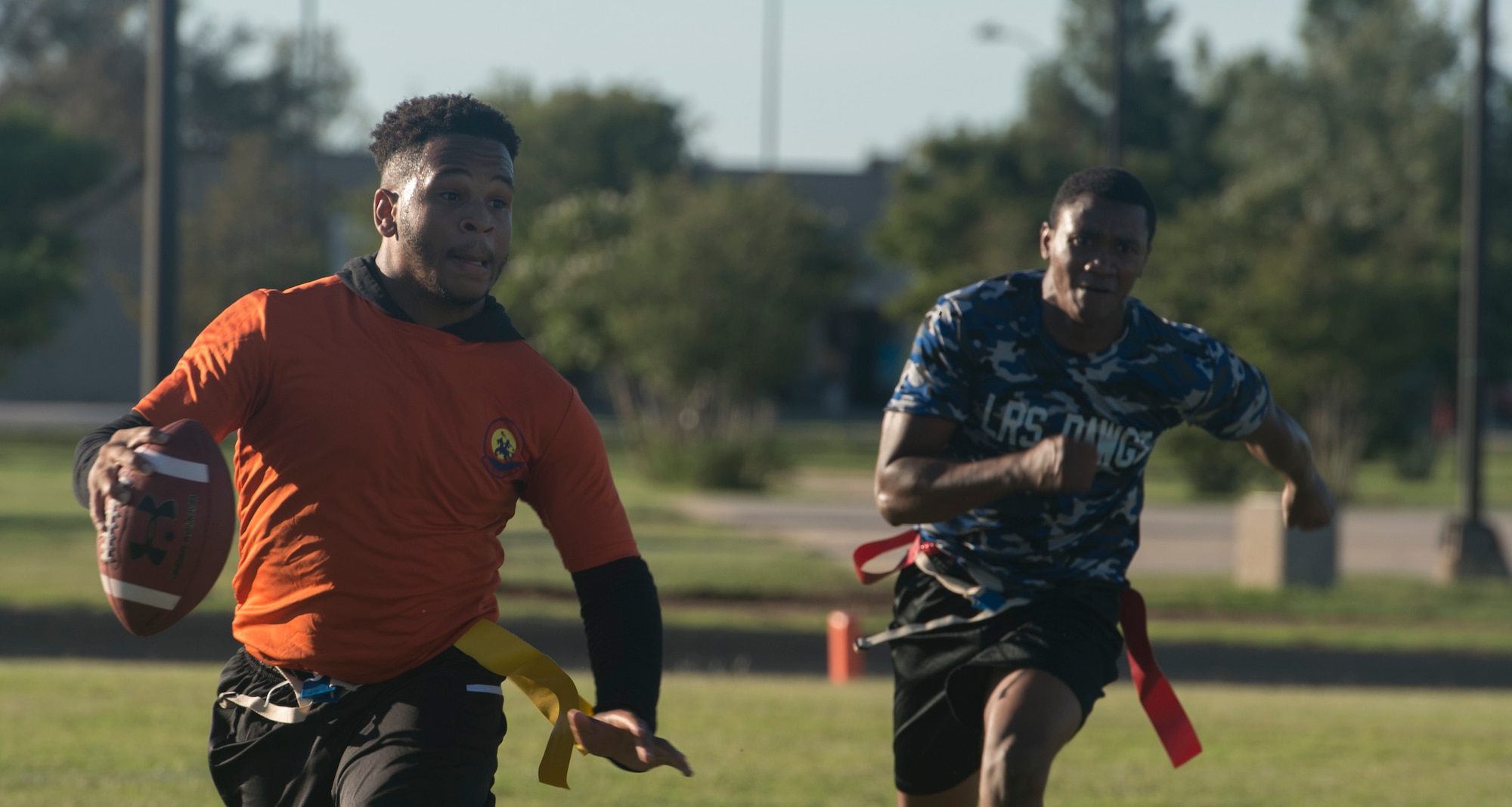 A player from the 97th Operations Support Squadron football team runs from a player from the 97th Logistics Readiness Squadron football team during the 97th Air Mobility Wing Flag Football Championships Sept. 28, 2018 on Altus Air Force Base, Okla. The 97th OSS and LRS played two games against each other with OSS winning the first, and LRS winning the second game to become the champions. (U.S. Air Force photo by A1C Jeremy Wentworth)