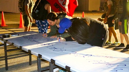 Two participants write down who they are marching for during the Fight for Life Suicide Prevention and Awareness Event at Edwards Air Force Base, California, Sept. 28-29. The event was an overnight relay ruck march, run or walk. (U.S. Air Force photo by Giancarlo Casem)