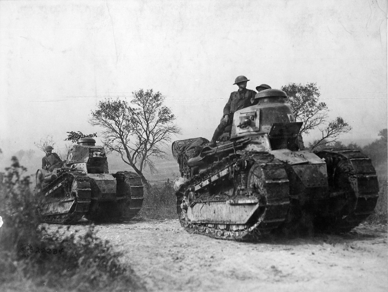 American tanks and soldiers on a road in France.
