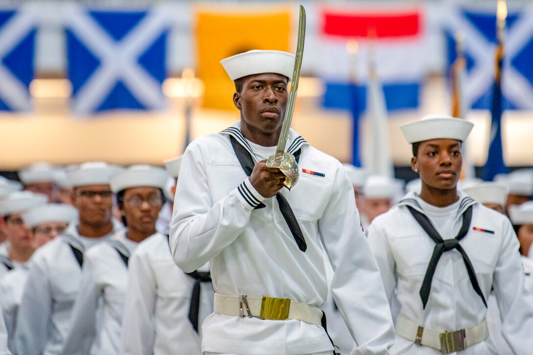 Sailors march in unison at a graduation ceremony.