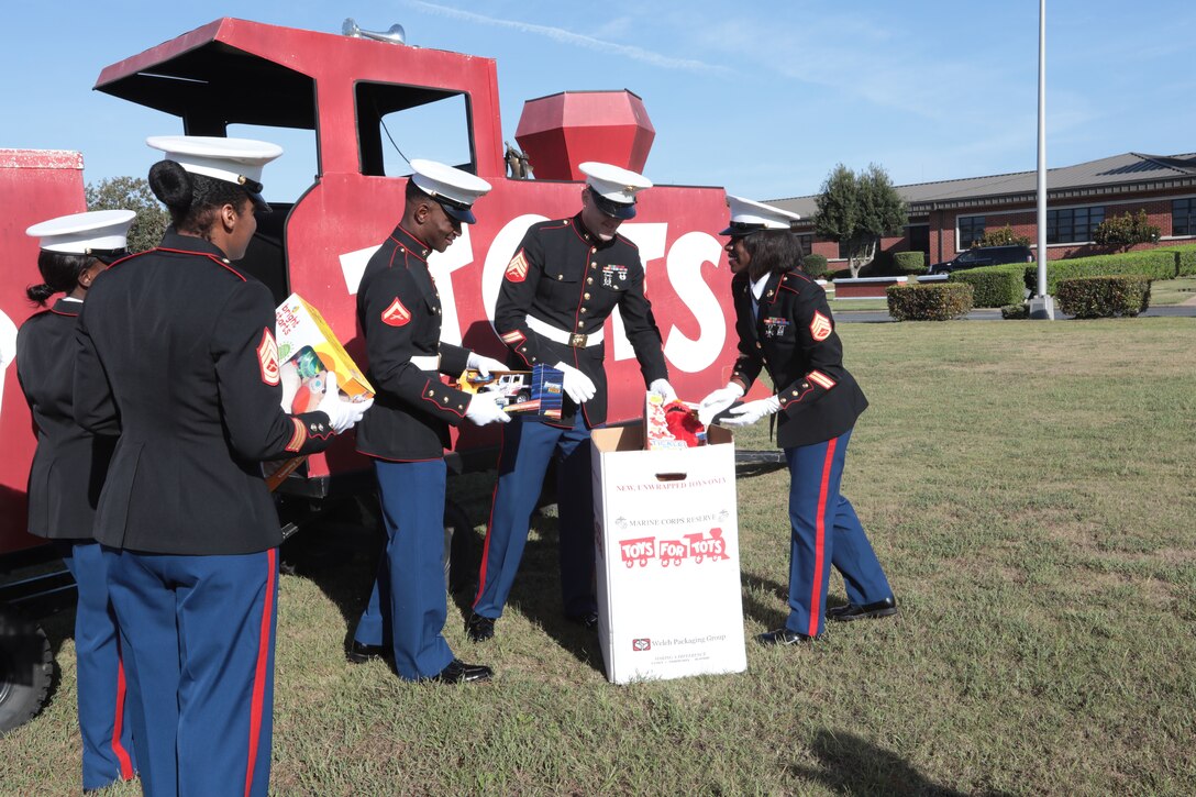 Several Marines put toys into a cardboard box