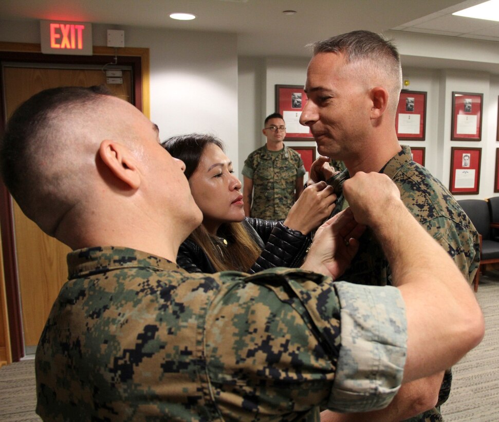 CAMP HUMPHREYS, Republic of Korea – Master Sgt. Adam Teaford (right), U.S. Marine Corps Forces Korea G3 future operations and plans chief and native of Grand Haven, Mich., promoted to his current pay grade, Oct. 1. Cheryl Teaford and Maj. William DeLeal, MARFORK G35 plans and policy officer, pinned on “Top” Teaford’s new rank.  (U.S. Marine Corps photo by Capt. John Parry/Released)