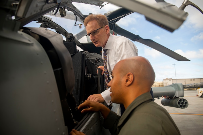 Navy undersecretary examines helicopter component.
