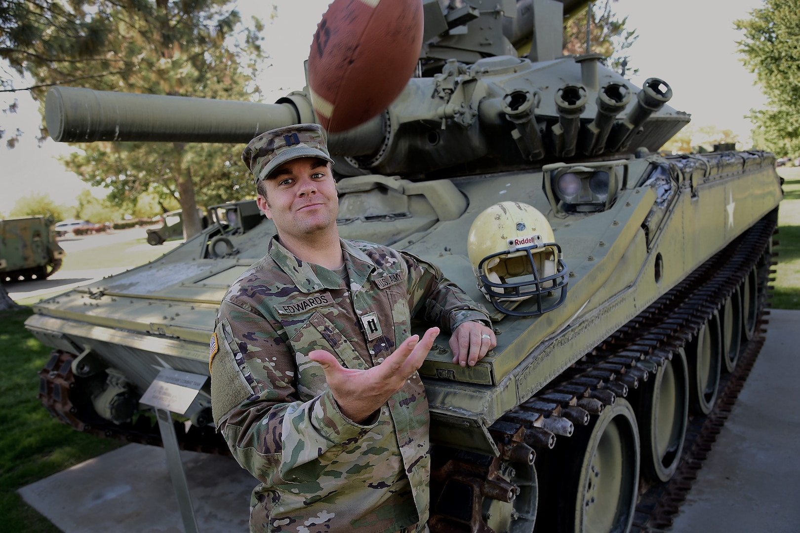 Idaho Army National Guard Capt. A.J. Edwards poses for a photo while tossing a football Sept. 27, 2018, on Gowen Field, Boise, Idaho. Edwards was struck by lightning on Sept. 30, 1998, at a football practice in Inkom, Idaho. He was wearing the helmet and holding the football shown. His teammates signed the football.