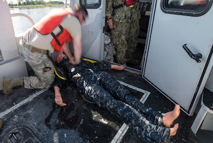 U.S. Air Force Staff Sgt. Curtis March, 628th Security Forces Squadron patrolman, demonstrates CPR during a SIMBBC course Sept. 26, 2018, at Joint Base Charleston’s Naval Weapons Station, S.C. The SIMBBCC curriculum arms security forces members with skills needed to conduct harbor patrol missions and covers techniques including man overboard drills, pier approaches, towing and anchoring.