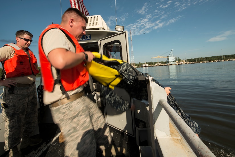 U.S. Air Force Senior Airman Ryan Olson, 628th Security Forces Squadron patrolman, pulls a mannequin out of the water during a man overboard drill during a Shore Installation Management Basic Boat Coxswain Course practical exercise Sept. 26, 2018, at Joint Base Charleston’s Naval Weapons Station, S.C. The SIMBBCC curriculum arms security forces members with skills needed to conduct harbor patrol missions and covers techniques including man overboard drills, pier approaches, towing and anchoring.