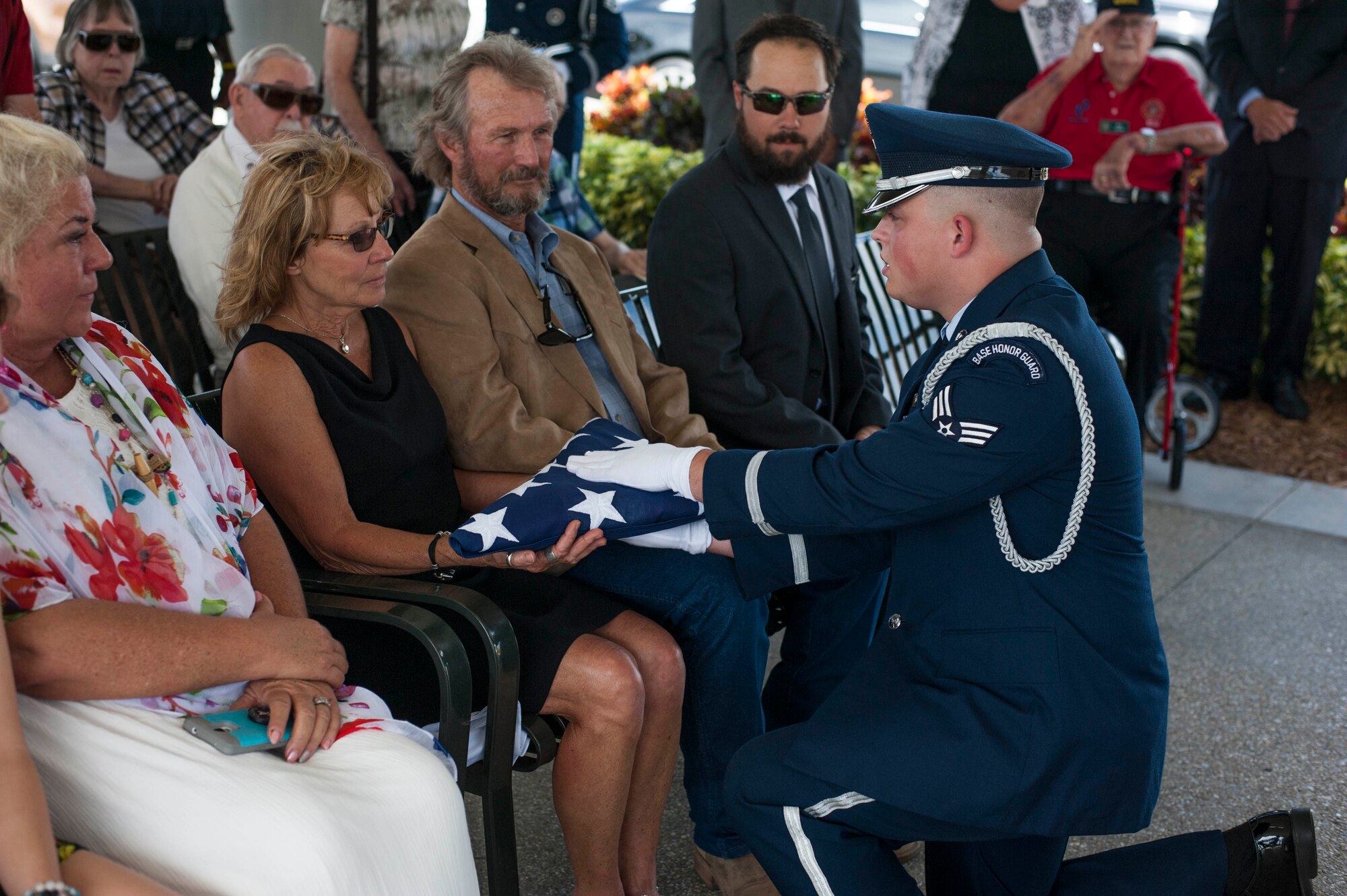 U.S. Air Force Senior Airman Hunter Fennell, a MacDill Air Force Base honor guardsman presents a folder U.S. flag to Cathy Haun, the daughter of Tech. Sgt. Earl W. Haun during his military funeral service at the Sarasota National Cemetery, Oct. 2, 2018.