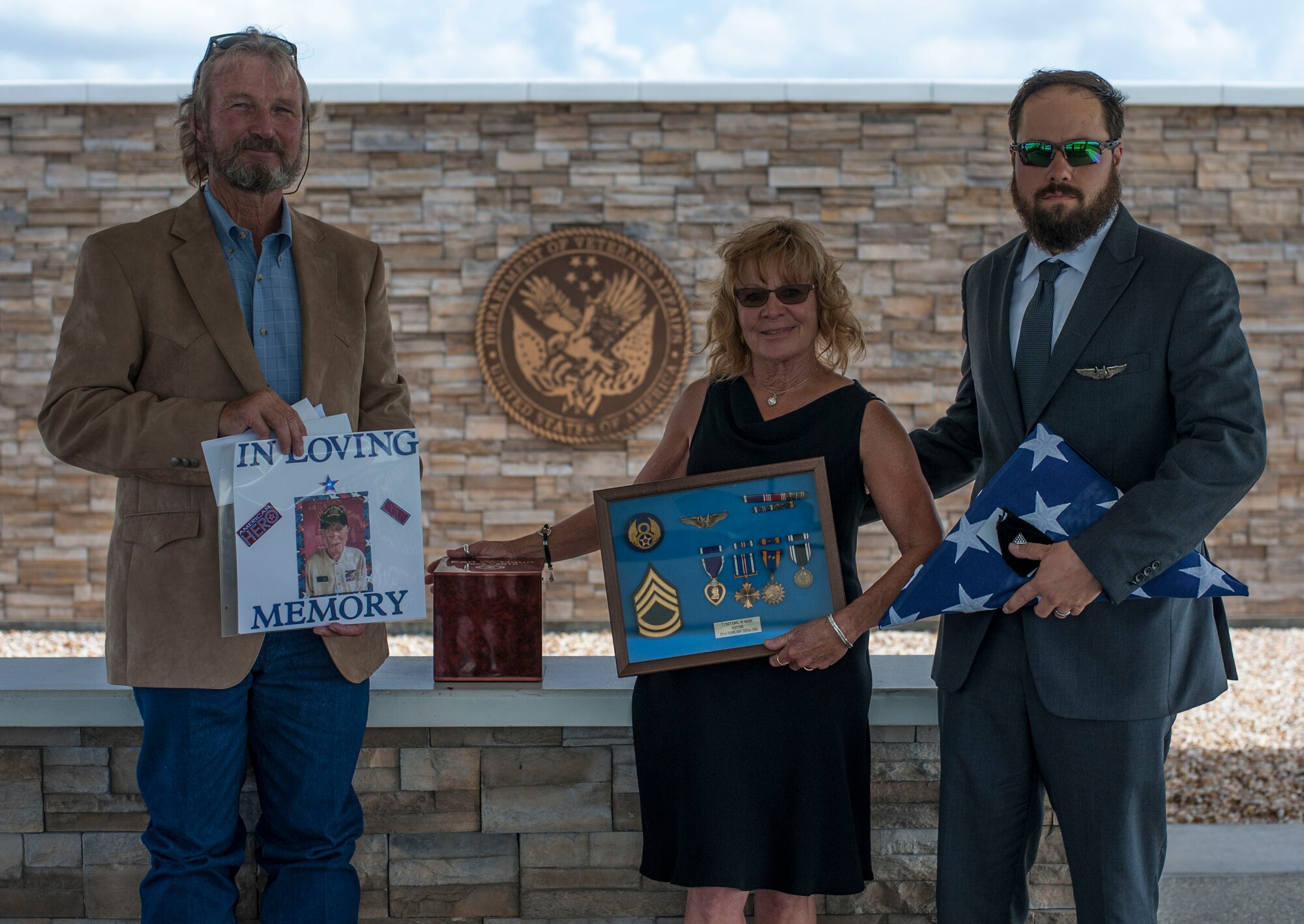 Cathy Haun, center, daughter of Tech. Sgt. Earl W. Haun, displays her father’s shadow box and urn with her husband and son after Earl’s military funeral service at the Sarasota National Cemetery, Oct. 2, 2018.