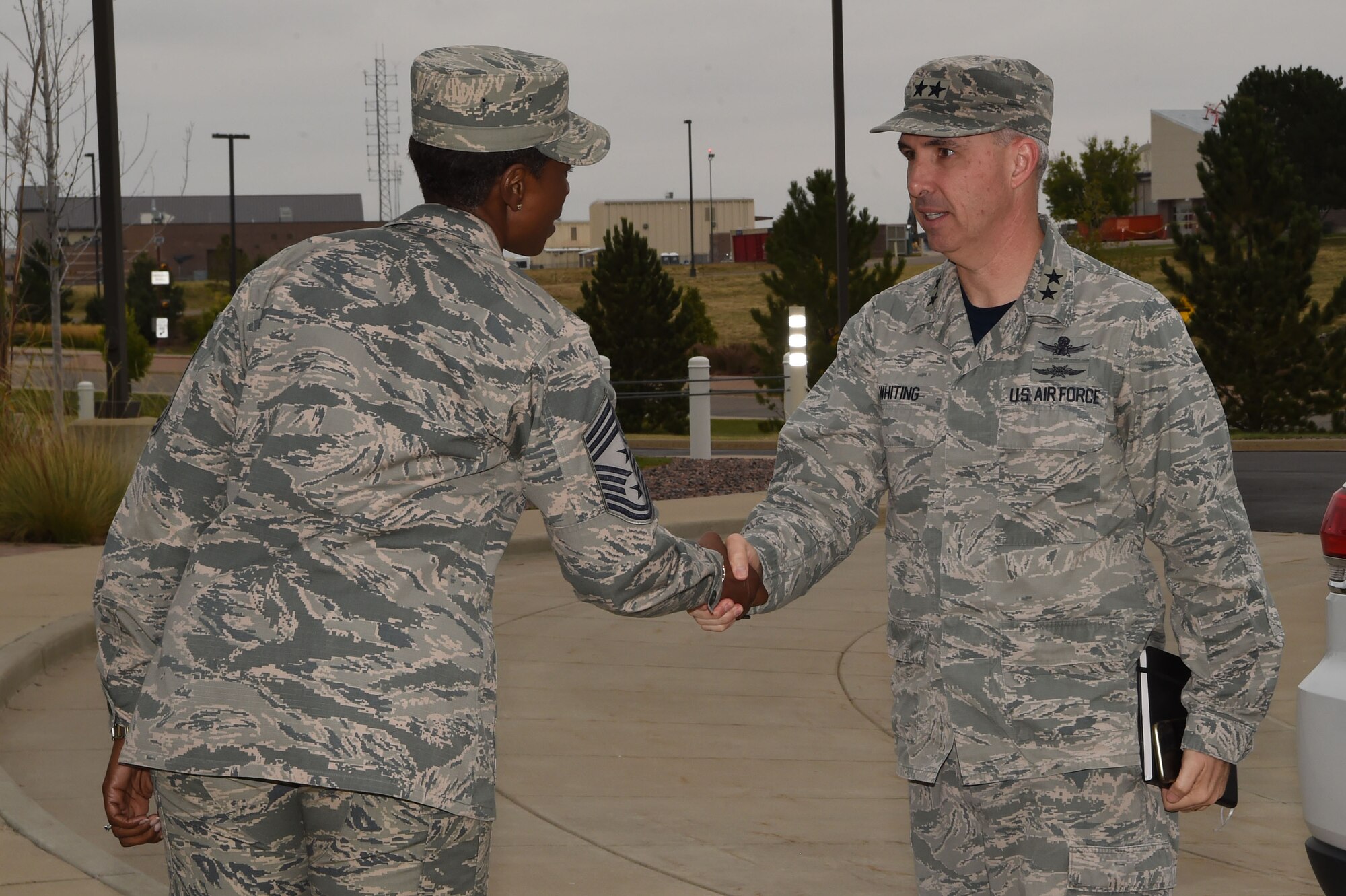 Chief Master Sgt. Tamar Dennis, 460th Space Wing command chief, greets Maj. Gen. Stephen Whiting, 14th Air Force commander, Air Force Space Command Sept. 28, 2018, on Buckley Air Force Base, Colorado. Whiting is responsible for leading and guiding a diverse team of Airmen charged with protecting and defending critical U.S. and allied space capabilities. (U.S. Air Force photo by Senior Airman Codie Collins)