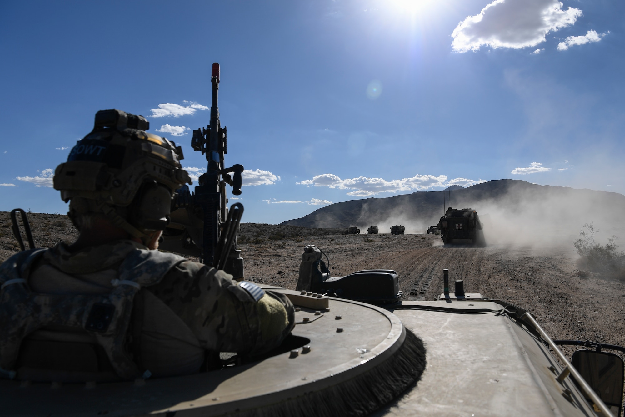 A Special Tactics Airman from the 21st Special Tactics Squadron from Pope Army Airfield, Fort Bragg, North Carolina, mans an M-240 machine gun and watches for potential threats on a convoy to a simulated attack on a city during a scenario as part of NTC 18-10 at Fort Irwin, California, Sept. 6, 2018.