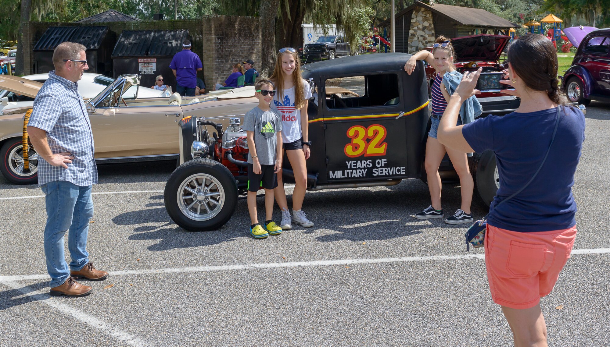 Retired U.S. Air Force Col. Nicholas Conyer looks on as his family poses for a photo in front of a 1930 Ford pickup during the 15th Annual Cruisin’ Keesler Car Show at Marina Park at Keesler Air Force Base, Mississippi, Sept. 29, 2018. The event is held to kick off Cruisin’ the Coast, a festival to celebrate classic cars, trucks and hot rods, where vehicles cruise down the 30-mile beachside highway in Mississippi. The event welcomed visitors, classic vehicles and presented several awards presentations. (U.S. Air Force photo by Andre' Askew)
