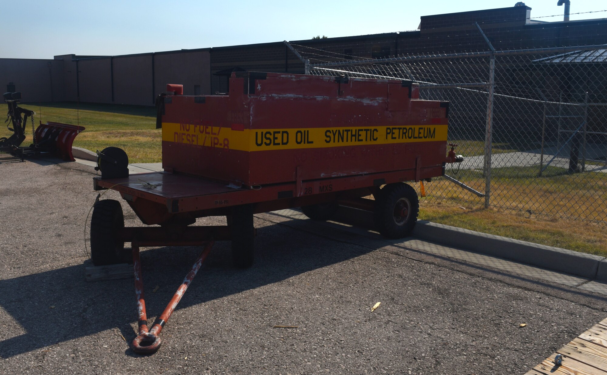 An oil trailer, similar to what was used in the SpillRaider trailer conversion, is still in use at Ellsworth Air Force Base, S.D., Sept. 17, 2018. The oil tank is removed from the deck of the trailer and replaced with one industrial-steel storage chest and two heavy-duty plastic storage chests. The storage chests are filled up with a fuel pump, absorbents and personal protective equipment for Airmen to use while cleaning up fuel on the flight line. (U.S. Air Force photo by Airman Christina Bennett)