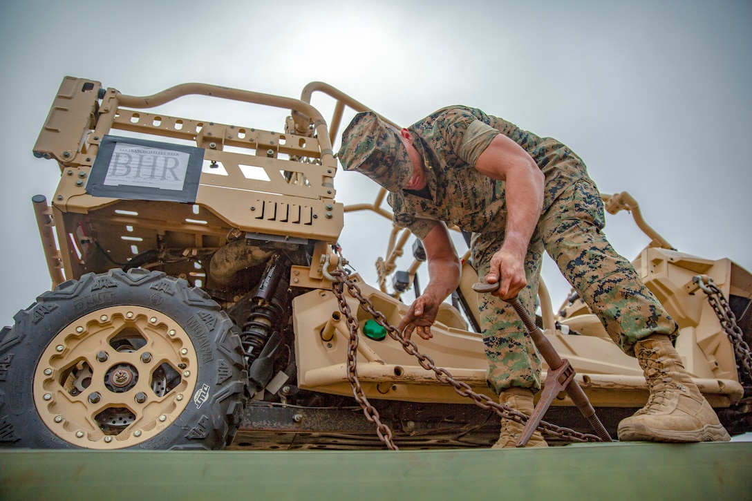 A marine removes chains from a utility vehicle.
