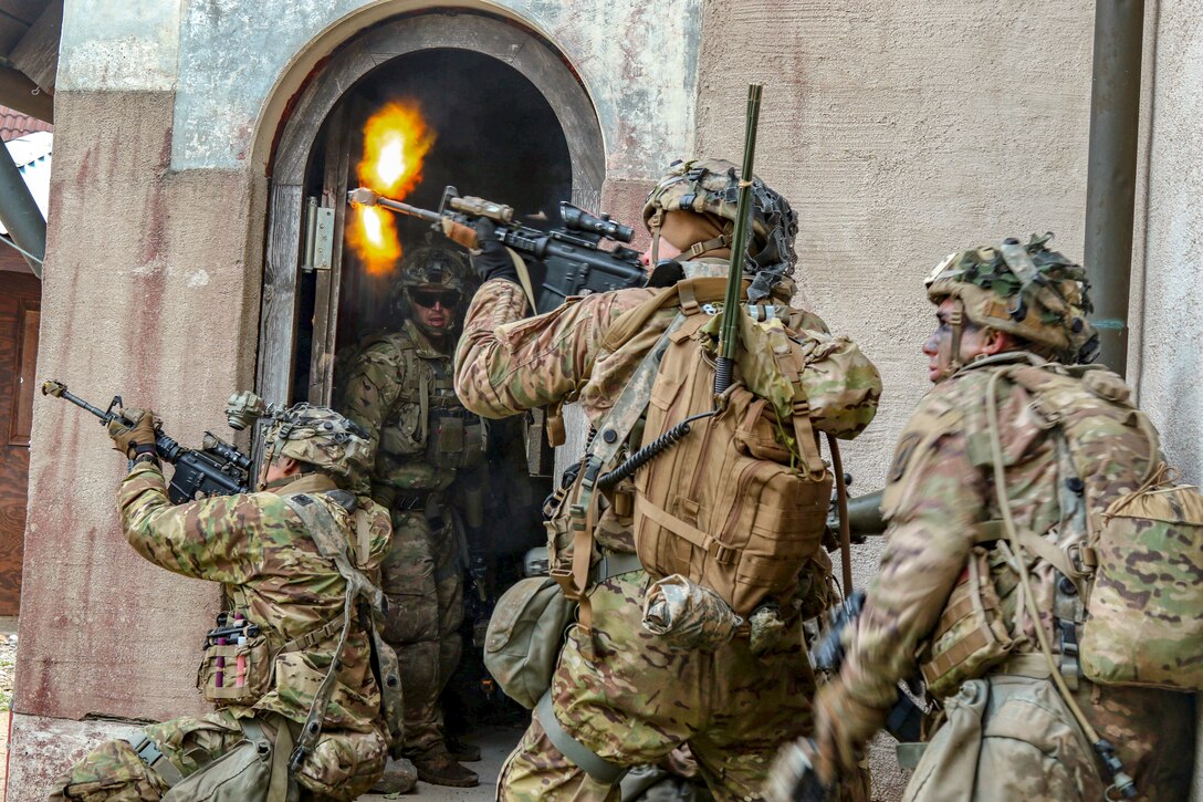 A group of soldiers aims and fires at offscreen mock opposing forces.