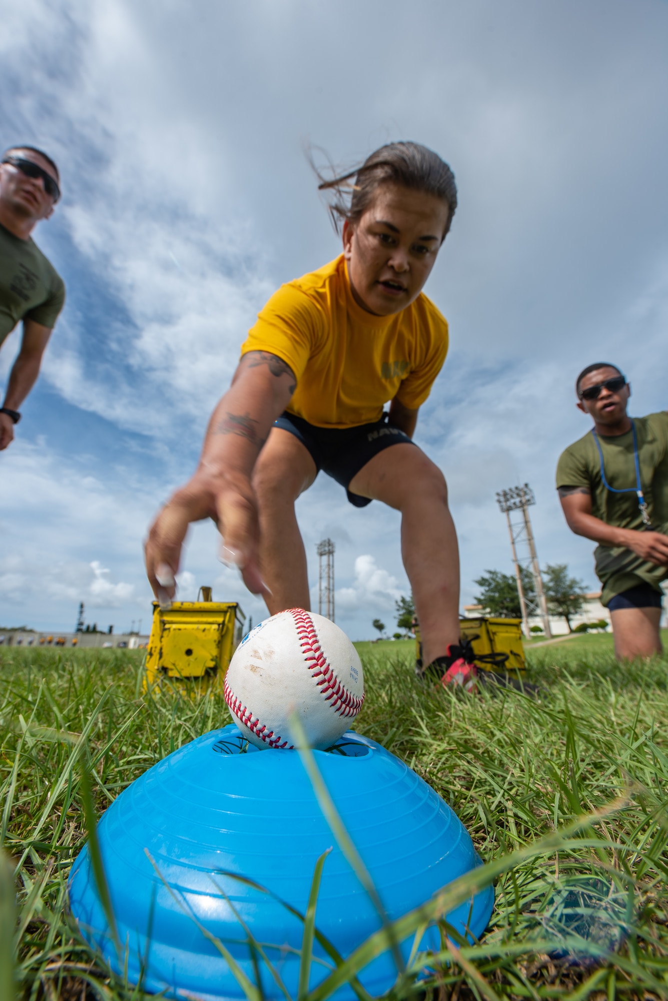 U.S. Navy Petty Officer 3rd Class Emily Pall, Okinawa Joint Experience Green Team student, reaches for a baseball during the Okinawa Joint Fitness Challenge Sept. 26, 2018, at Kadena Air Base, Japan. During the challenge, baseballs were used to simulate grenades. Teams were deducted points based on the accuracy of their throws. (U.S. Air Force photo by Staff Sgt. Micaiah Anthony)