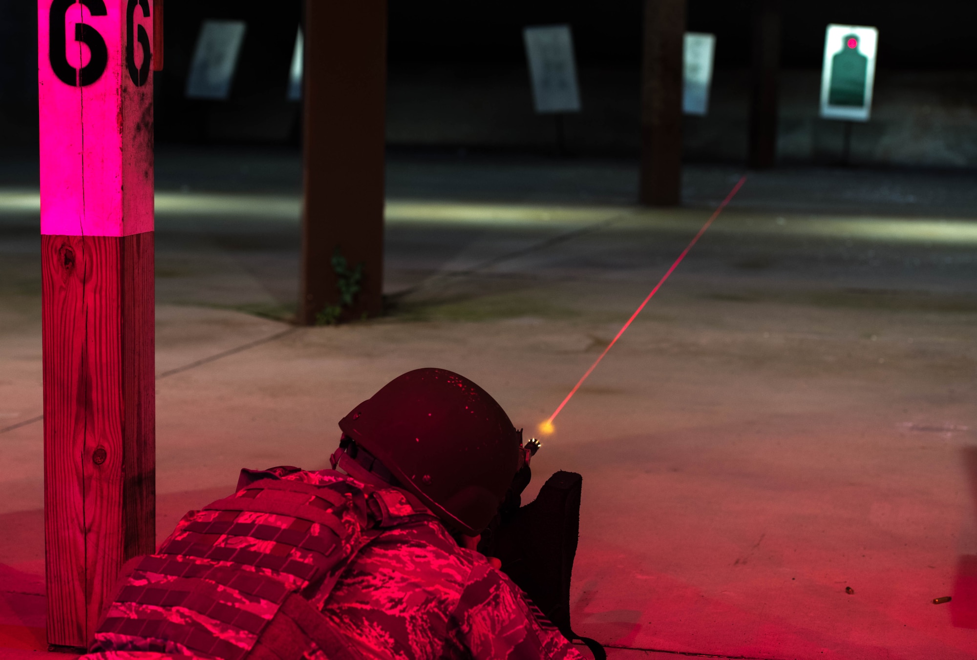 U.S. Air Force Tech. Sgt. Jared Martin, 633rd Security Forces Squadron flight chief uses an Advanced Target Pointer/Illuminator/Aiming Laser during night fire weapons training at Joint Base Langley-Eustis, Virginia, Aug. 23, 2018. Combat Arms Training and Maintenance instructors keep Airmen mission ready with weapons training and equipment u. (U.S. Air Force photo by Airman 1st Class Anthony Nin Leclerec)