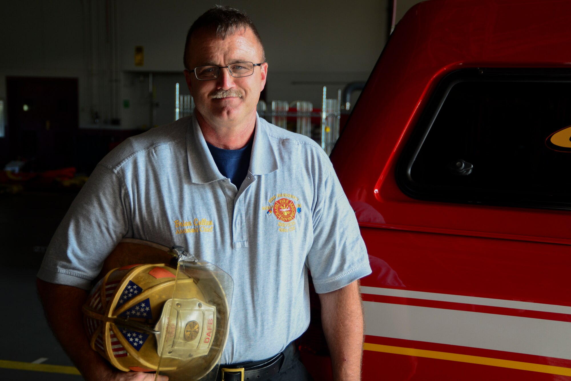 Brian Cullen, 436th Civil Engineer Squadron assistant fire chief, poses for a picture with a firefighter helmet at Dover Air Force Base, Del., Sept. 26, 2018. According to Cullen, safety measures for firefighters have changed dramatically from when he first started in 1980. (U.S. Air Force photo by Airman 1st Class Jonathan W. Harding)