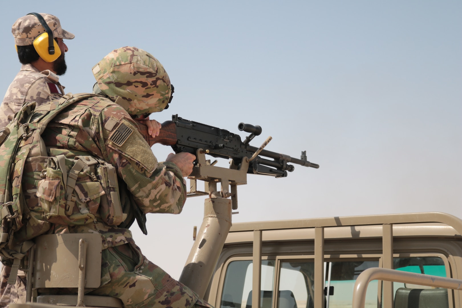 A U.S. Soldier with the 578th Brigade Engineer Battalion fires down range as a Qatari safety observes his target at Al-Ghalail range, Sep. 12, 2018. The range provided a unique opportunity for Soldiers to build rapport with the Qatari soldiers from a Qatari base near Camp As Sayliyah. (U.S. Army photo by 1st. Lt. Stefan Tenorio)