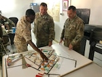Forces Armee Djibouti (FAD) Lt. Meraneh, liaison officer, explains design and construction planning to Kentucky Guardsmen Command Sgt. Maj. Jerry Sipe, 201st Engineer Battalion, and Maj. Christopher Hettinger, Bilateral Affairs Officer for the State Partnership Program in Djibouti, at an Engineer Regiment Camp, Sept. 23, 2018. As part of the State Partnership Program, Service members from Kentucky and Djibouti met to discuss engineering best practices.