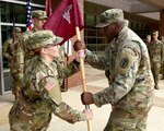 First Sgt. Brittany Graham (left) takes the U.S. Army Institute of Surgical Research, Headquarters and Headquarters Company guidon from Capt. Cleveland Bryant Jr., USAISR company commander, during a change of responsibility ceremony at Joint Base San Antonio-Fort Sam Houston Sept. 28.