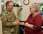 Col. (Dr.) Jerome Buller (left), commander of the U.S. Army Institute of Surgical Research at Joint Base San Antonio-Fort Sam Houston, presents Claudia Wood with a command coin Sept. 26 for 50 years of federal service. Wood, a supply technician at the USAISR, retired during an informal ceremony and potluck lunch Sept. 27.