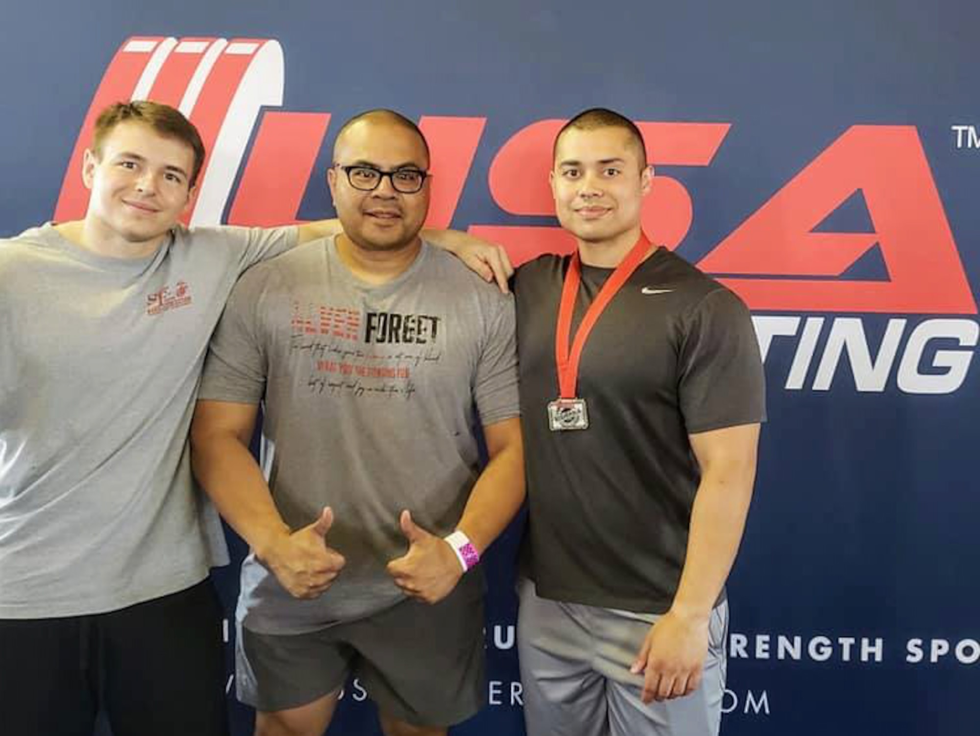 Senior Airman Zachary Nelson, left, Tech. Sgt. Nick Soriano, middle, and Staff Sgt. Christopher LaCour, right, pose for a photo during the Northwest Regional USA Powerlifting Competition July 29, 2018. Nelson placed second in the 74 kg weight class and LaCour place second in the 93 kg weight class which qualified them for Nationals in Spokane, Washington, Oct. 11-15, 2018.