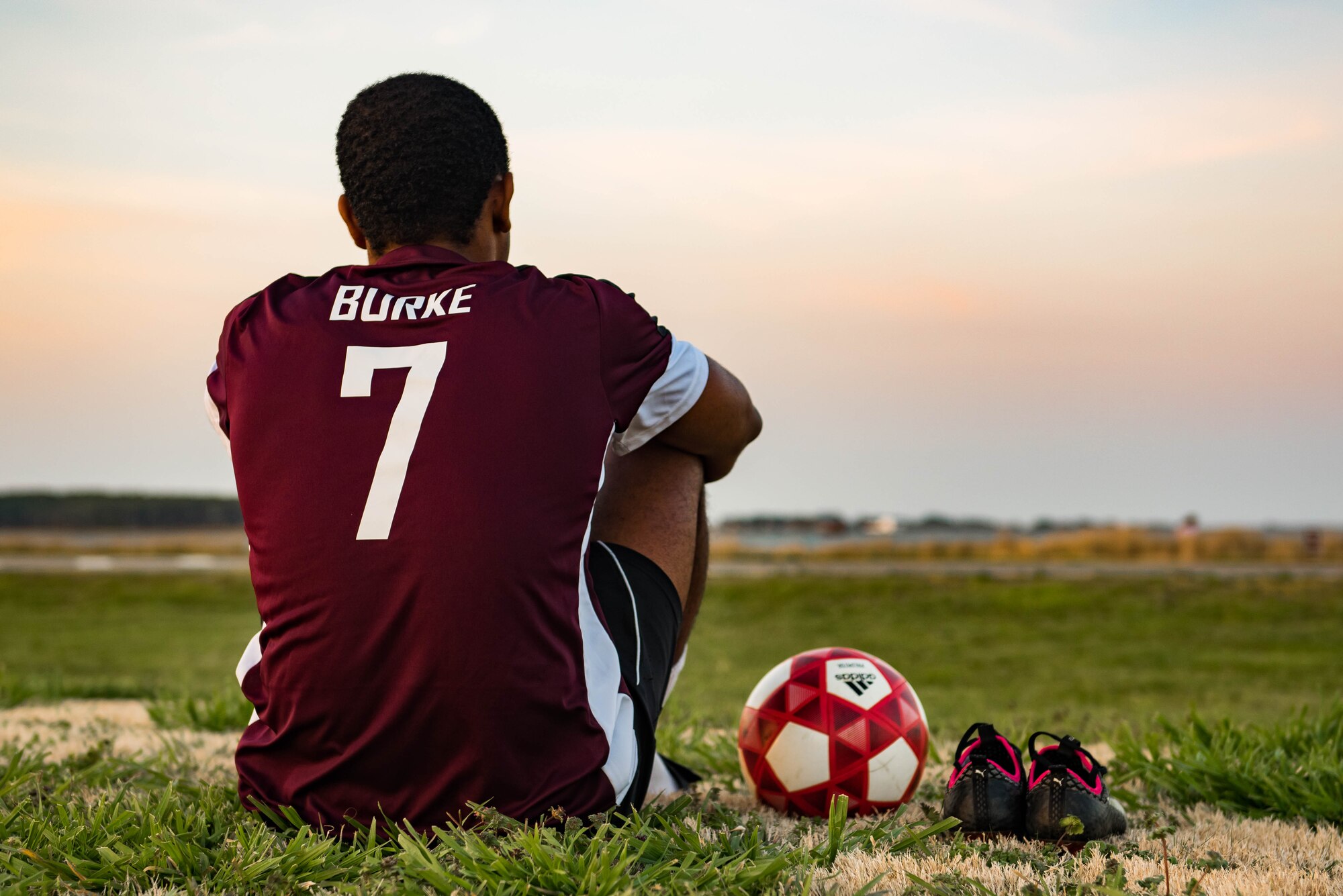 U.S. Air Force Airman 1st Class Jairzinho Burke, 633rd Air Base Wing Judge Advocate paralegal, sits at the soccer field during the intramural soccer season at Joint Base Langley-Eustis, Virginia. Burke started playing soccer at the age of 5 in Maypen, Jamaica.