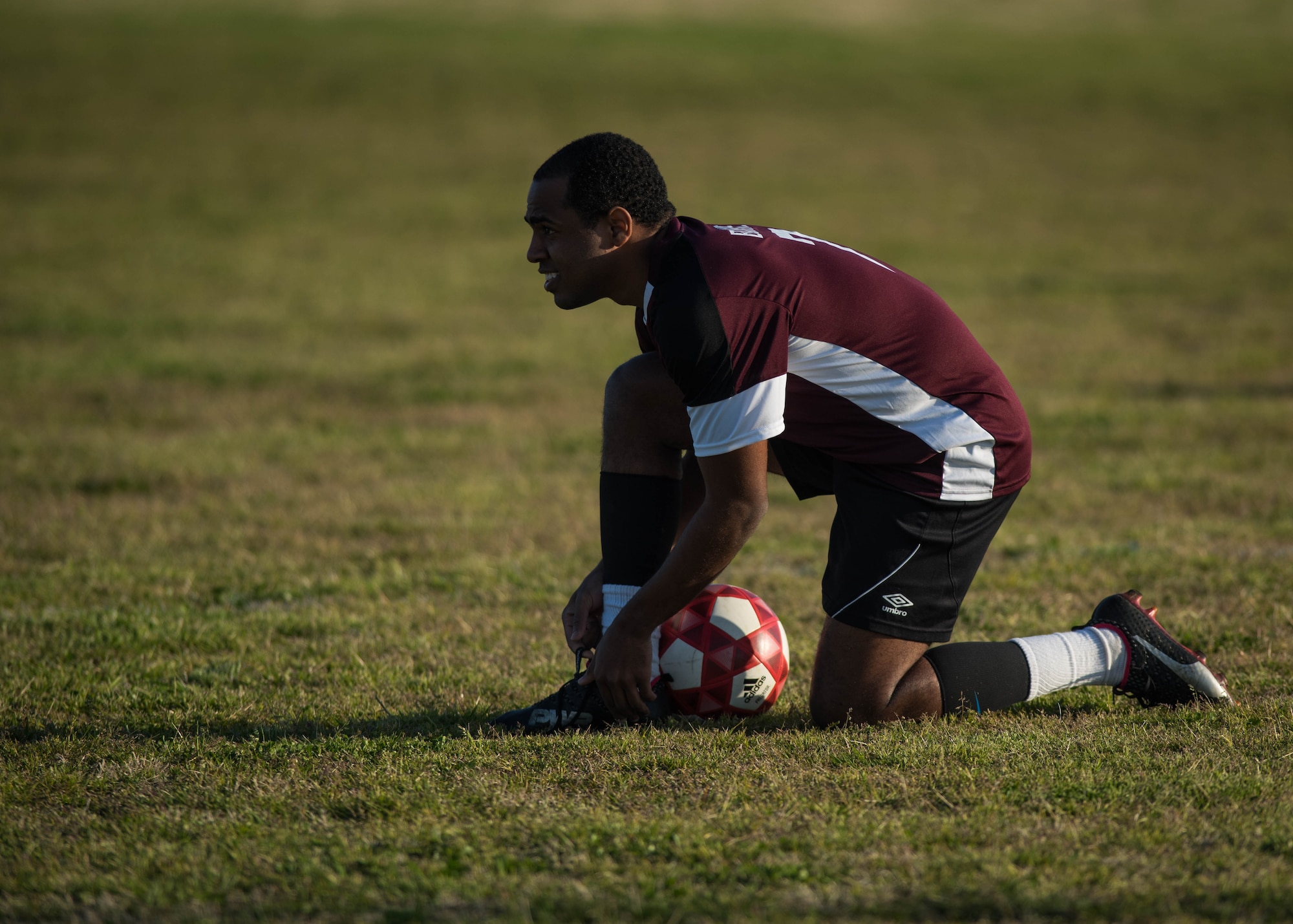 U.S. Air Force Airman 1st Class Jairzinho Burke, 633rd Air Base Wing Judge Advocate paralegal, tightens his laces during an intramural soccer game at Joint Base Langley-Eustis, Virginia, April 12, 2018. Burke played soccer on semi-pro team “Villages Football Club” in Orlando, Florida, during the summer of 2016. (U.S. Air Force photo by Airman 1st Class Anthony Nin Leclerec)