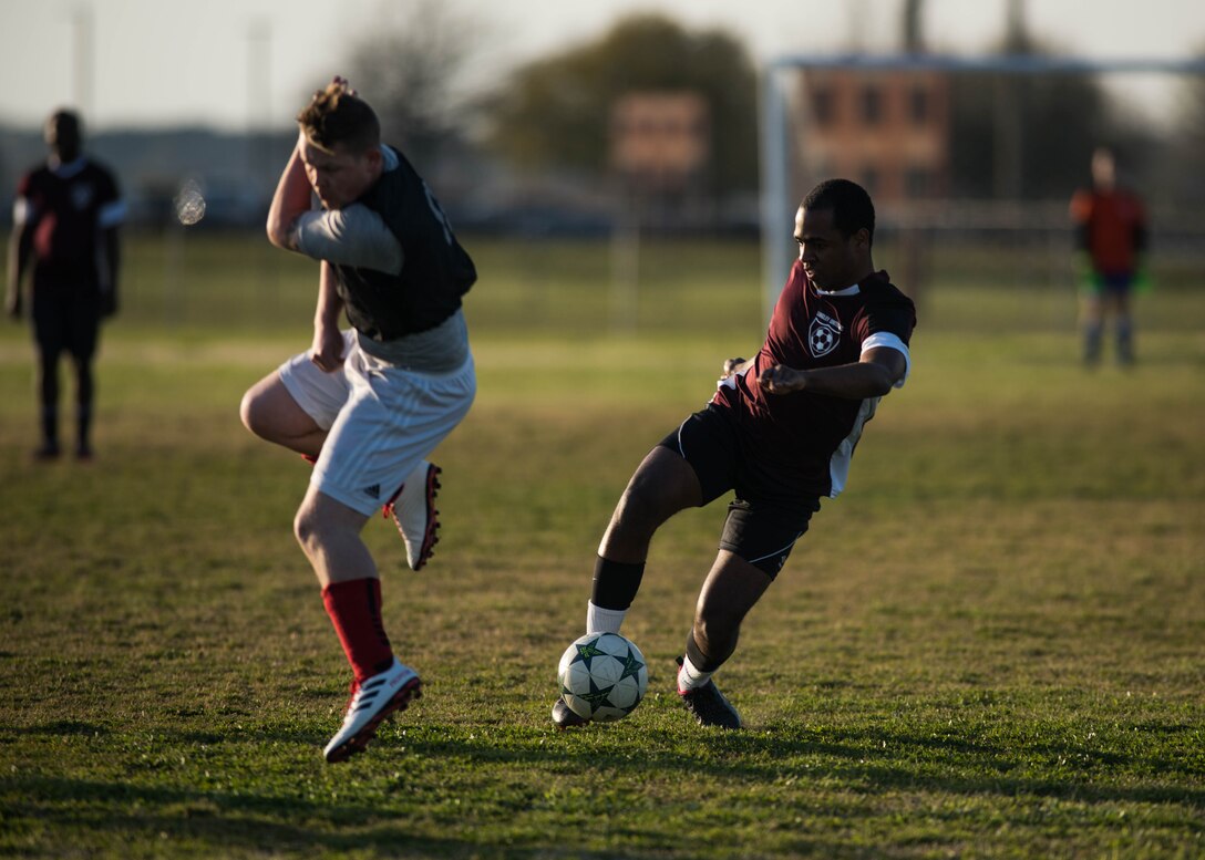 U.S. Air Force Airman 1st Class Jairzinho Burke, 633rd Air Base Wing Judge Advocate paralegal, jukes a defender during an intramural soccer game at Joint Base Langley-Eustis, Virginia, April 12, 2018.