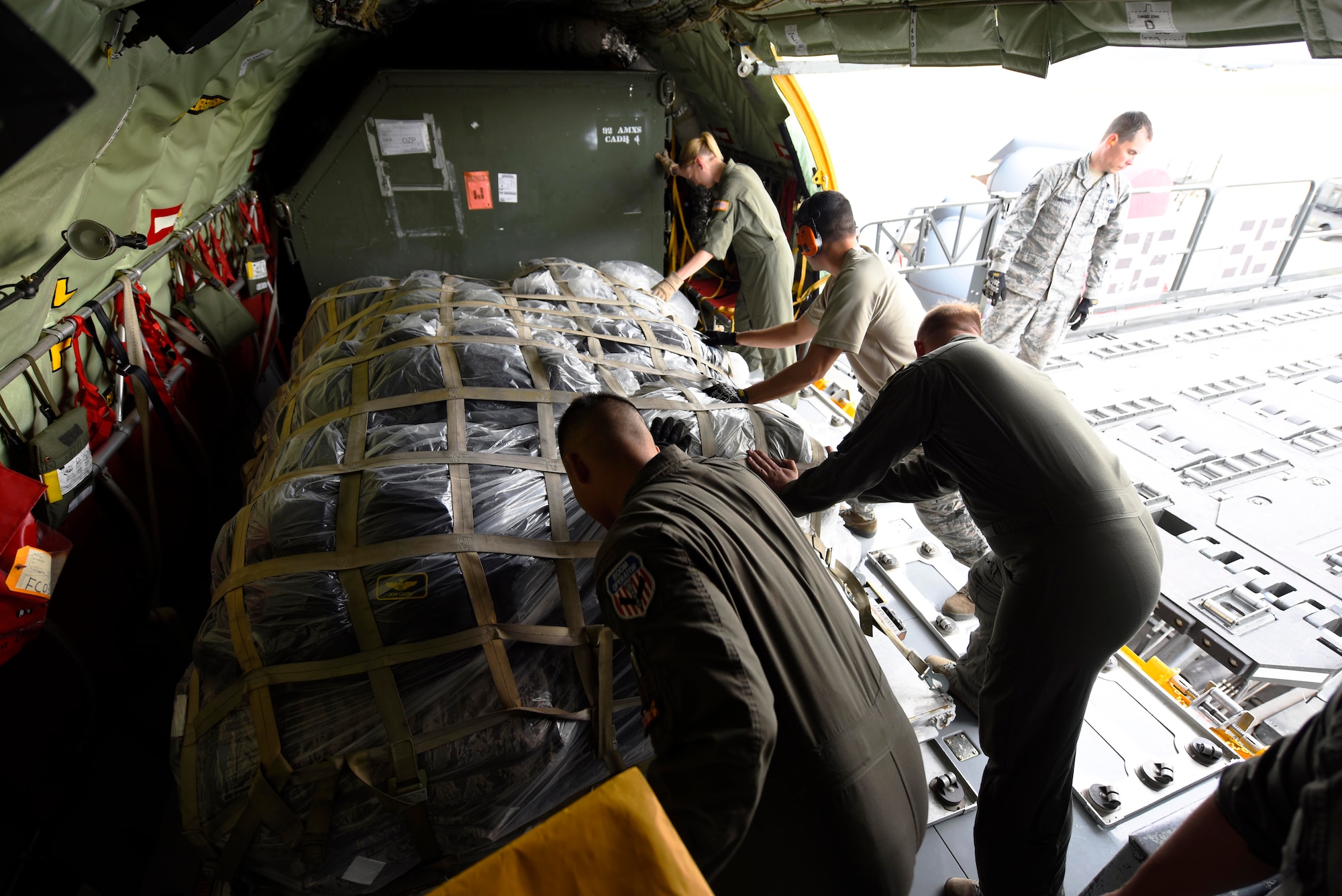 Airmen from the 92nd Air Refueling Squadron and Logistics Readiness Squadron push cargo into a KC-135 Stratotanker at Fairchild Air Force Base, Washington, September 2018. Mobility Airmen fuel the fight, provide airlift needed for supplies and personnel, and enable versatile and timely effects through contingency response ensuring mission success. (U.S. Air Force photo/Airman 1st Class Lawrence Sena)