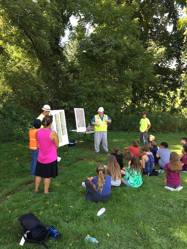 Steve Dunbar (second from left) and New England District partners talk water quality with Strong Middle School students during a STEM presentation.