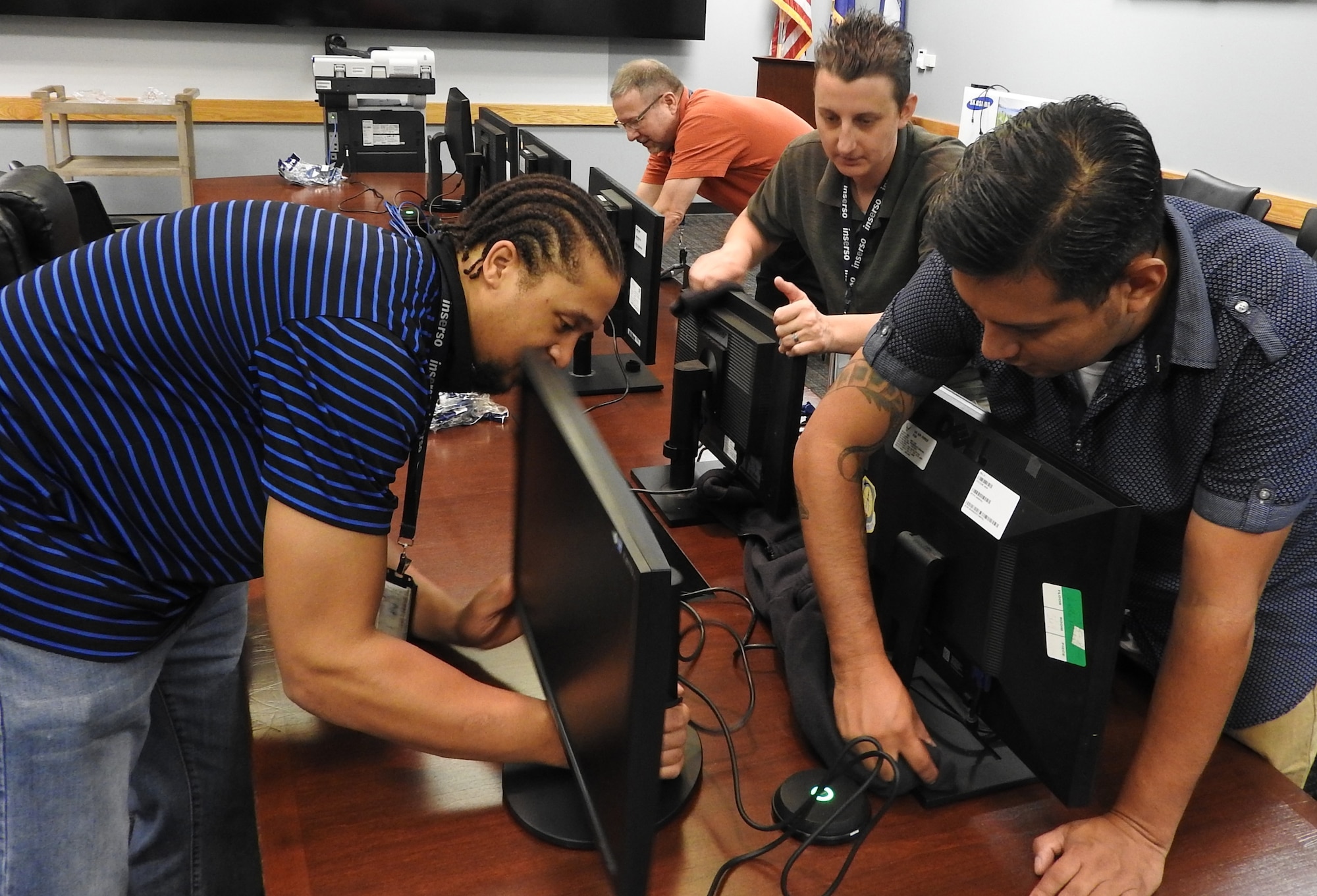 AFIMSC technicians help transform a conference room into a war room for end of fiscal year close out activities, Sept. 14. Setting up monitors from left to right, Tremaine Eubanks, Thomas McDade, Tiffany Brown, and John Garza. (U.S. Air Force Photo by Ed Shannon)