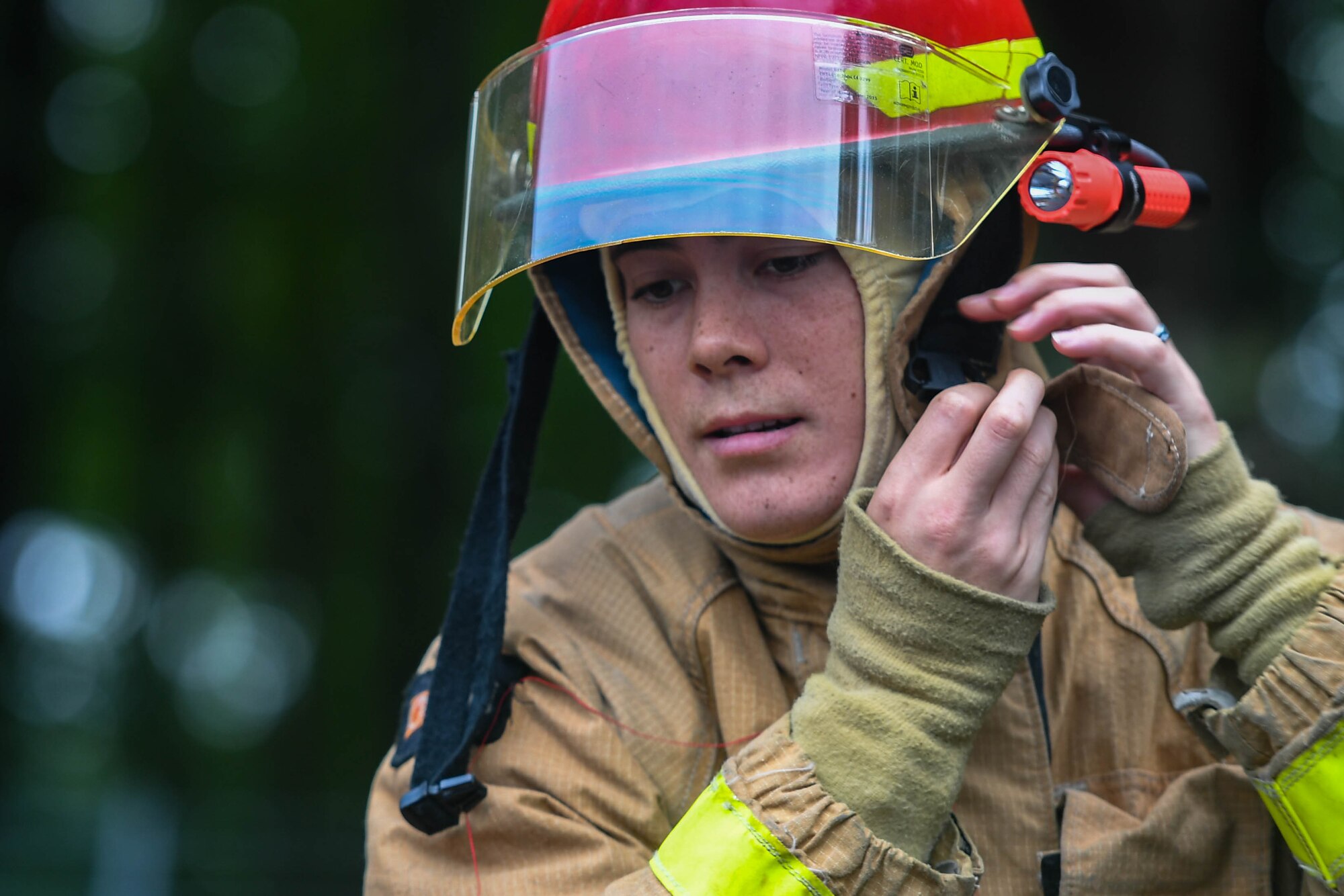 U.S. Army Capt. Morgan Carter, 690th Rapid Port Opening Element, 832nd Transportation Battalion, 597th Transportation Brigade logistics officer, dons fire protection equipment during a Fire and Ice Challenge at Joint Base Langley-Eustis, Virginia, Sept. 28, 2018. Soldiers competed against teams from Transportation Headquarters, Fort Lee, the 832rd Trans. Btn., and the 597th Trans. Bde., in the three-part challenge consisting of donning fire protection equipment, extinguishing a fire and a simulated casualty rescue, and sealing pipes and holes in a damage control simulator. (U.S. Air Force photo by Senior Airman Derek Seifert)