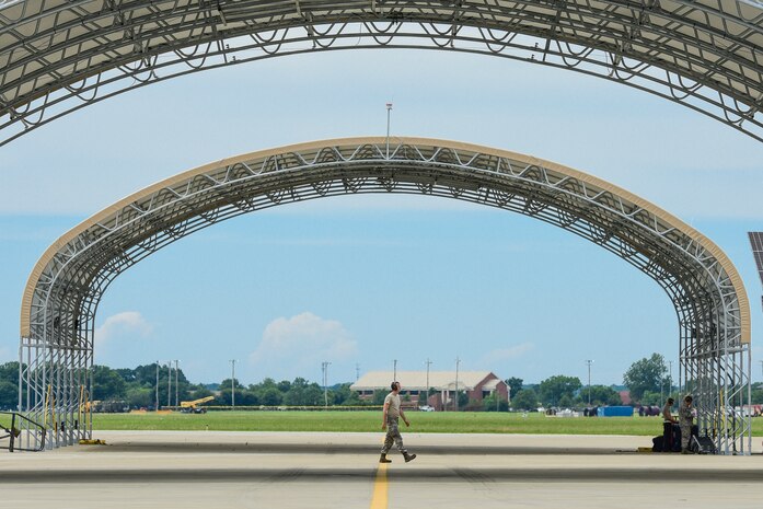 A U.S. Air Force crew chief assigned to the 27th Fighter Wing walks between sun shelters on the flightline at Joint Base Langley-Eustis, Va., June 19, 2017. The newly built sun shelters can now assist in the protection of the Airmen from rain and sun rays. (U.S. Air Force photo/Airman 1st Class Tristan Biese)