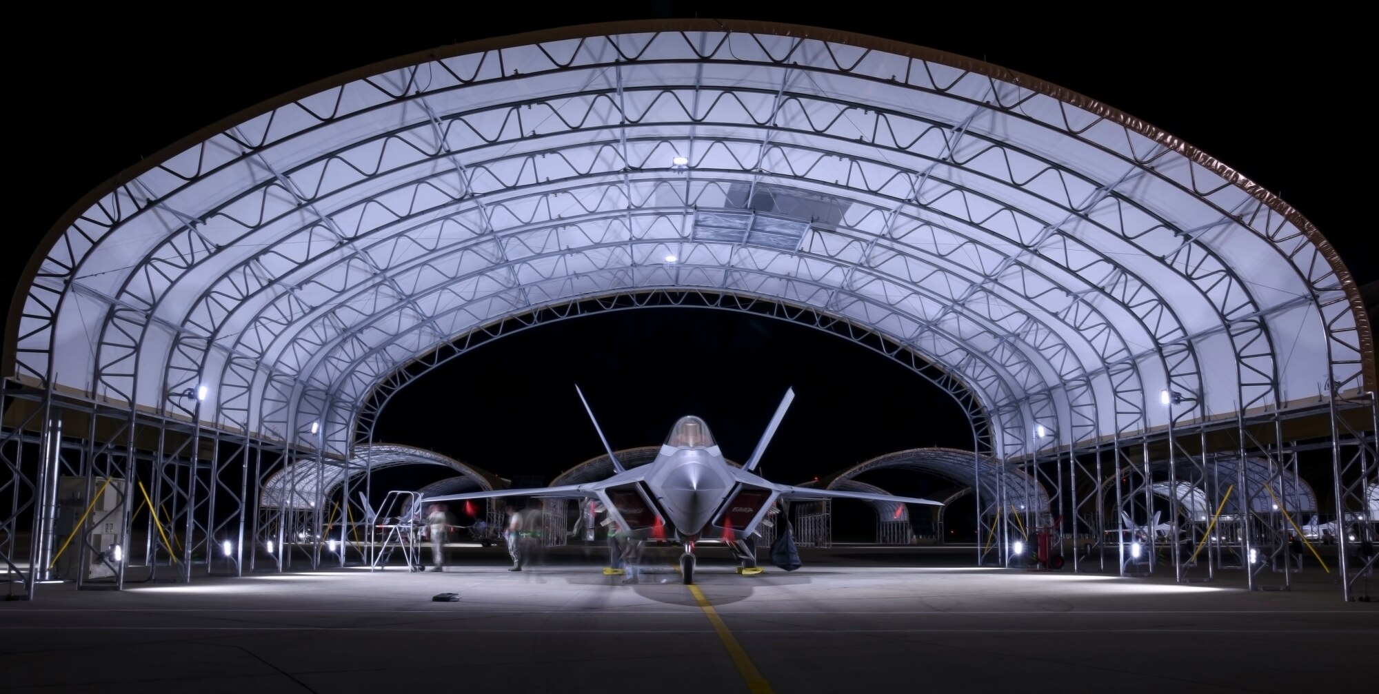 U.S. Air Force Airmen assigned to the 94th Aircraft Maintenance Unit and the 27th Fighter Wing finish inspecting an F-22 Raptor at Joint Base Langley-Eustis, Va., June 26, 2017. The newly built sun shelters are equipped with lights that illuminate the entire aircraft during hours of darkness, allowing those working under them to have better visualization. (U.S. Air Force photo/Airman 1st Class Tristan Biese)