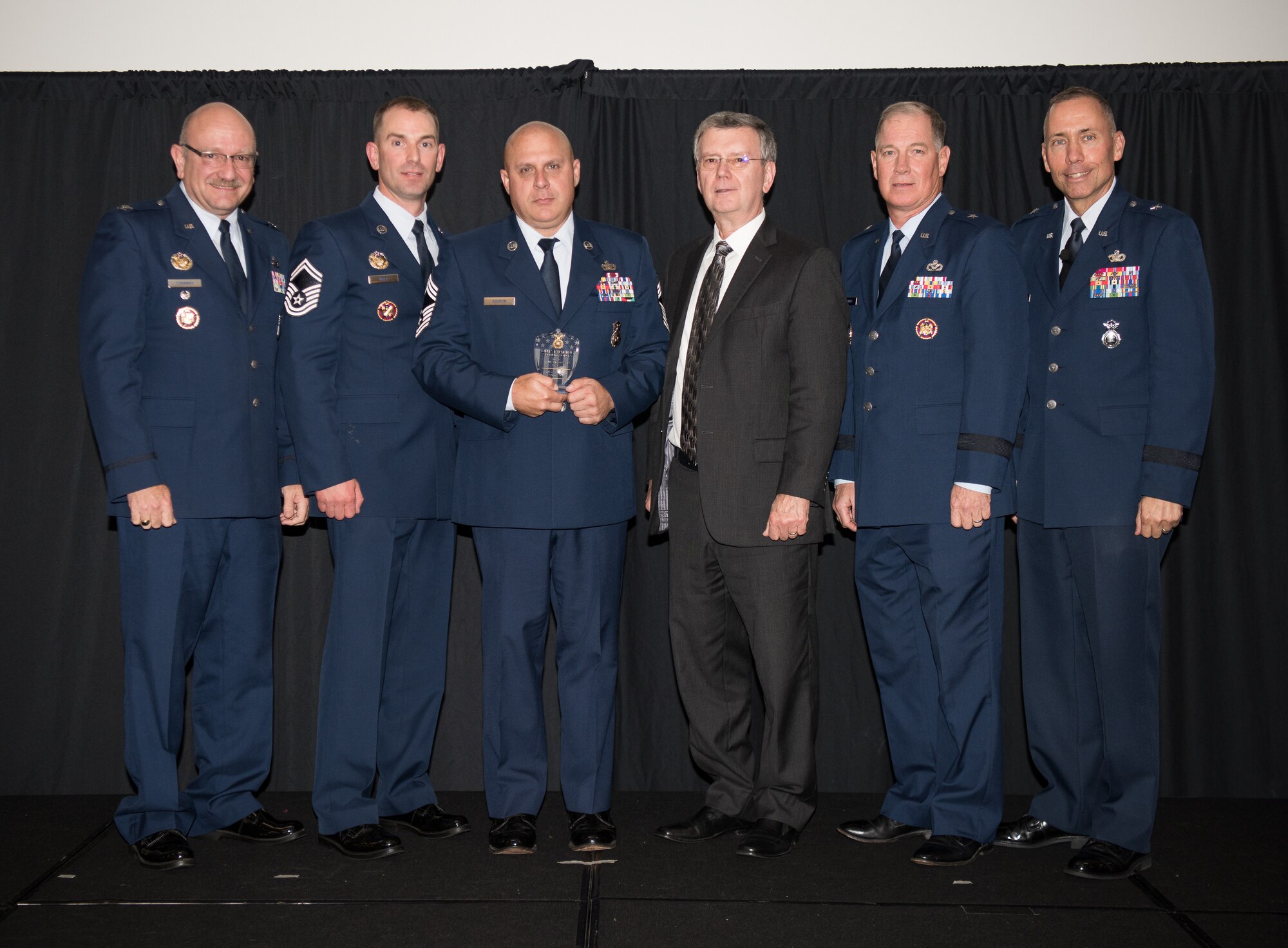 Chief Master Sgt. Donald Souron, 157th Security Forces Squadron (157th SFS), New Hampshire, receives the Air National Guard Outstanding Air Reserve Component Security Forces Airman of 2017 Award on behalf of the actual recepient, Senior Airman Brandan Abel, 157th SFS, at the 2018 Air National Guard Security Forces Squadron Dinner and Awards Banquet at the National Center for Employee Development Conference Center in Norman, Oklahoma, Sept. 12, 2018. Every year, leadership from all of the Air National Guard security forces squadrons meet in one place to discuss past, current and upcoming topics that impact the career field, as well as recognize outstanding security forces Airmen. (U.S. Air National Guard Photo by Staff Sgt. Kasey M. Phipps)