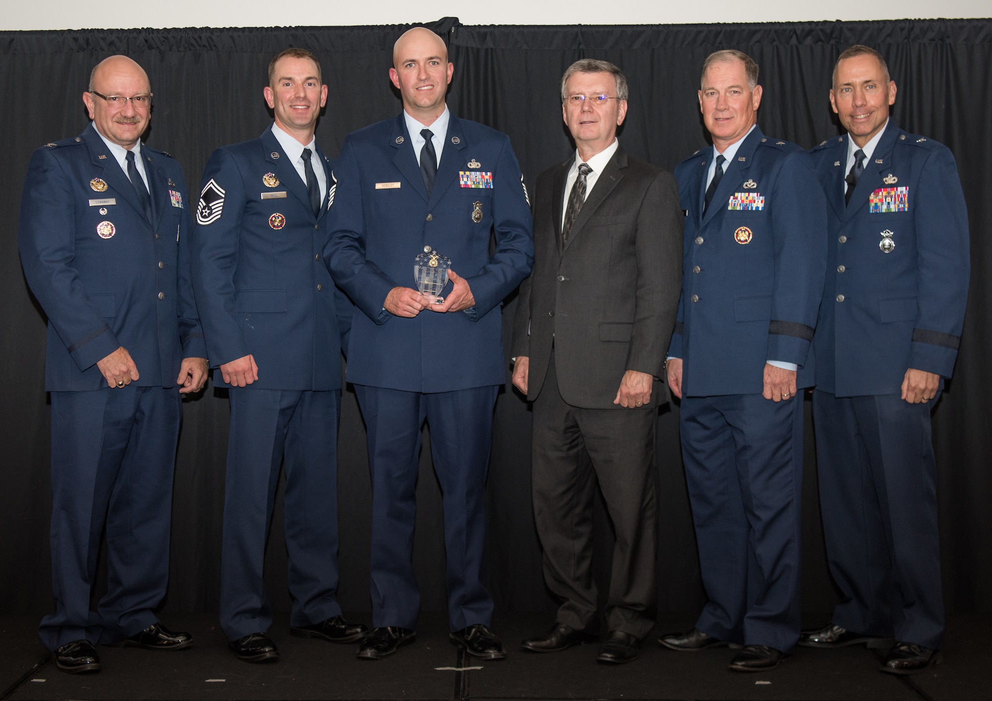 Master Sgt. Michael Hensley, 129th Security Forces Squadron, Moffett Field, California, receives the Air National Guard Outstanding Air Reserve Component Security Forces Noncommisioned Officer of 2017 Award at the 2018 Air National Guard Security Forces Squadron Dinner and Awards Banquet at the National Center for Employee Development Conference Center in Norman, Oklahoma, Sept. 12, 2018. Every year, leadership from all of the Air National Guard security forces squadrons meet in one place to discuss past, current and upcoming topics that impact the career field, as well as recognize outstanding security forces Airmen. (U.S. Air National Guard Photo by Staff Sgt. Kasey M. Phipps)